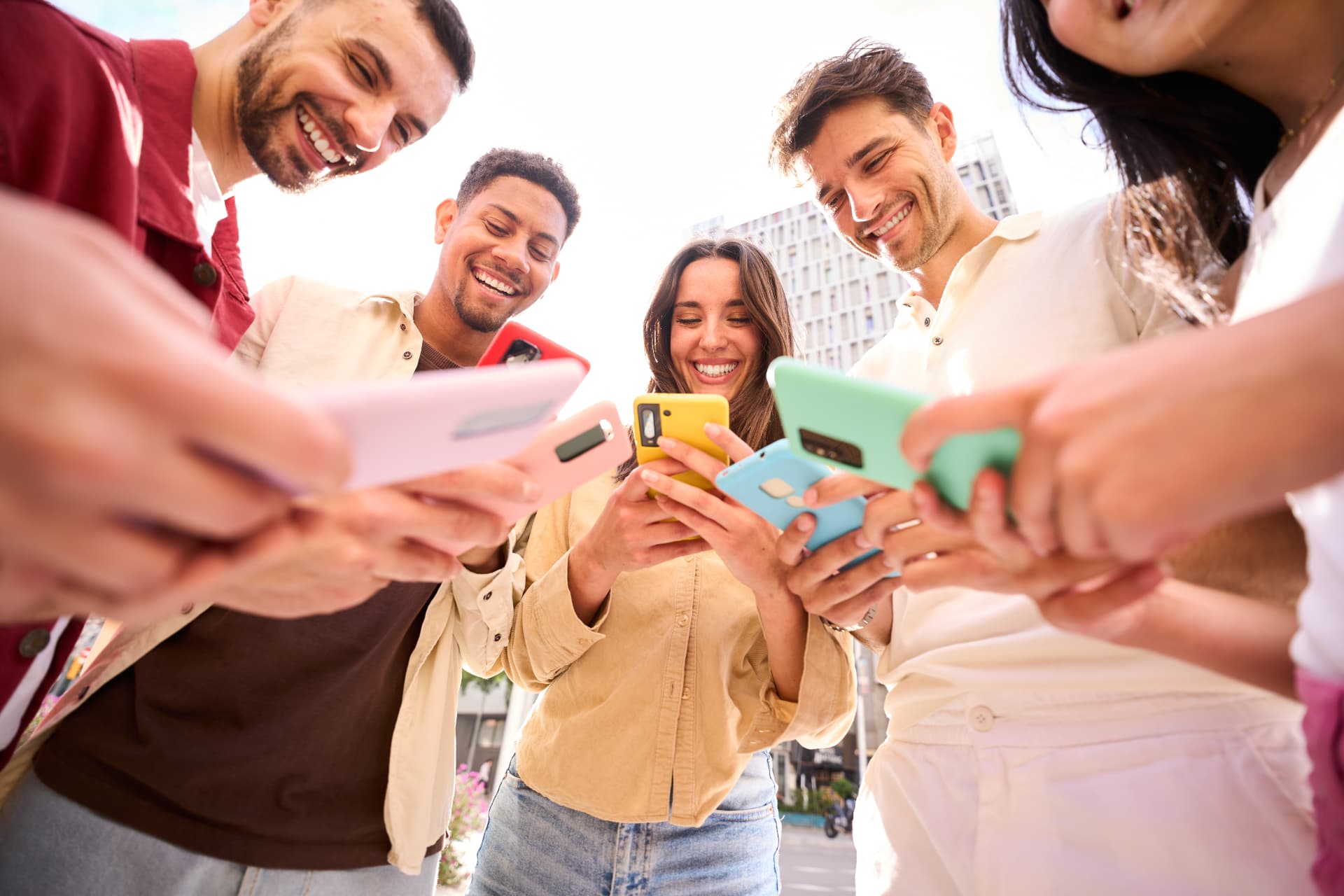 Friends smiling together over their phones